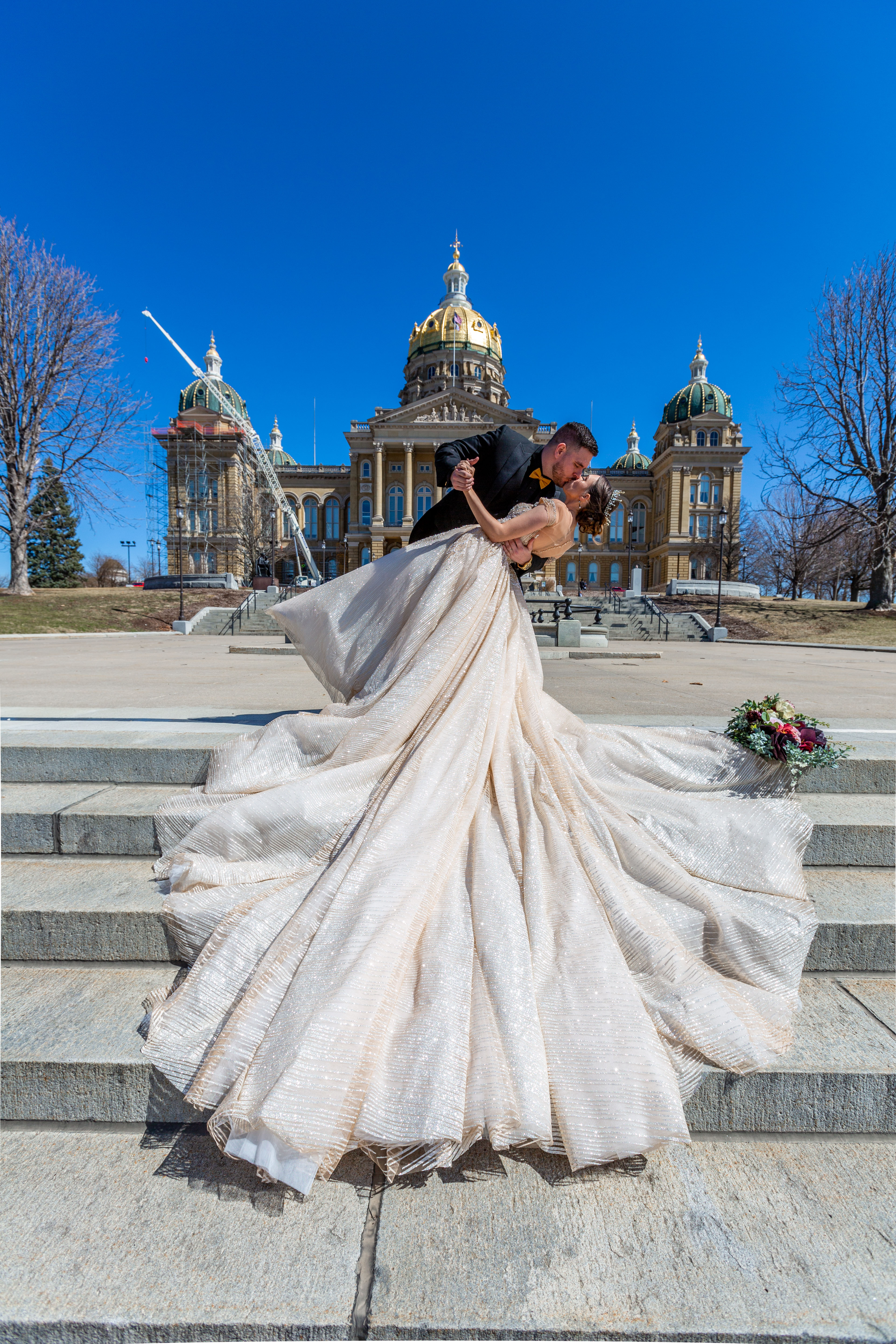 Caitlyn and her husband sharing a dip kiss on the Iowa State Capitol steps