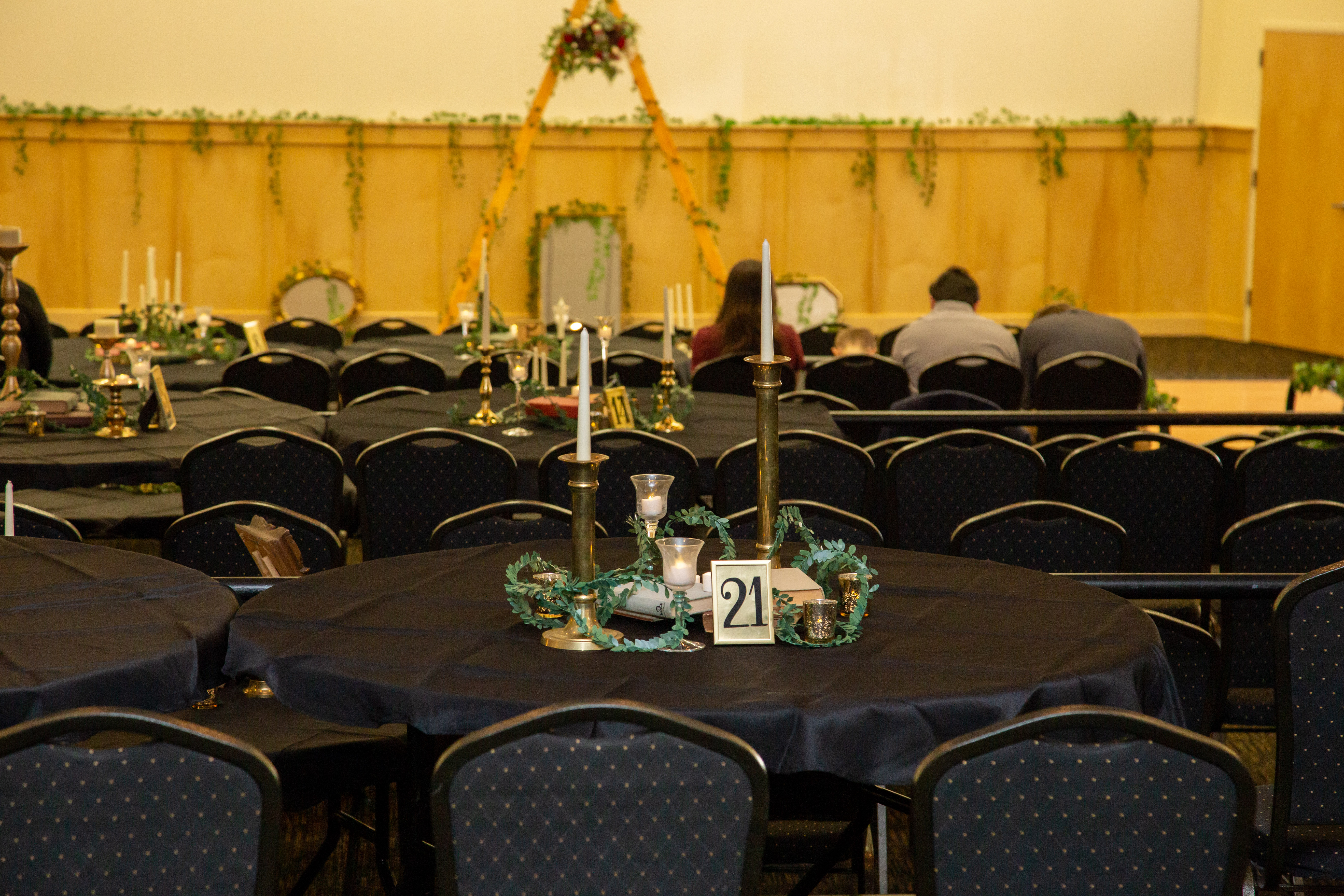 Reception hall with black linen tables and candlelit centerpieces