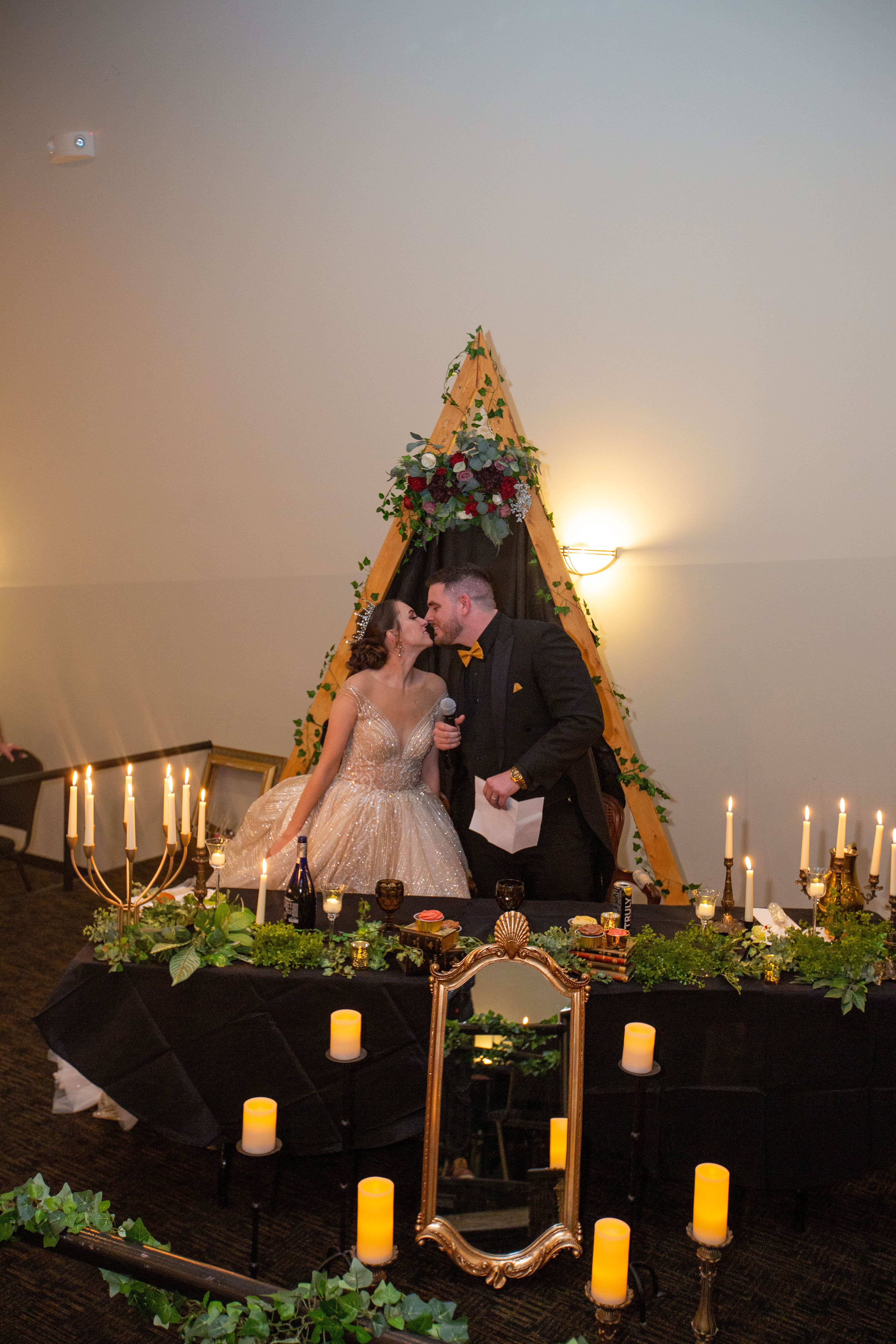 Sweetheart table with candles and floral arch