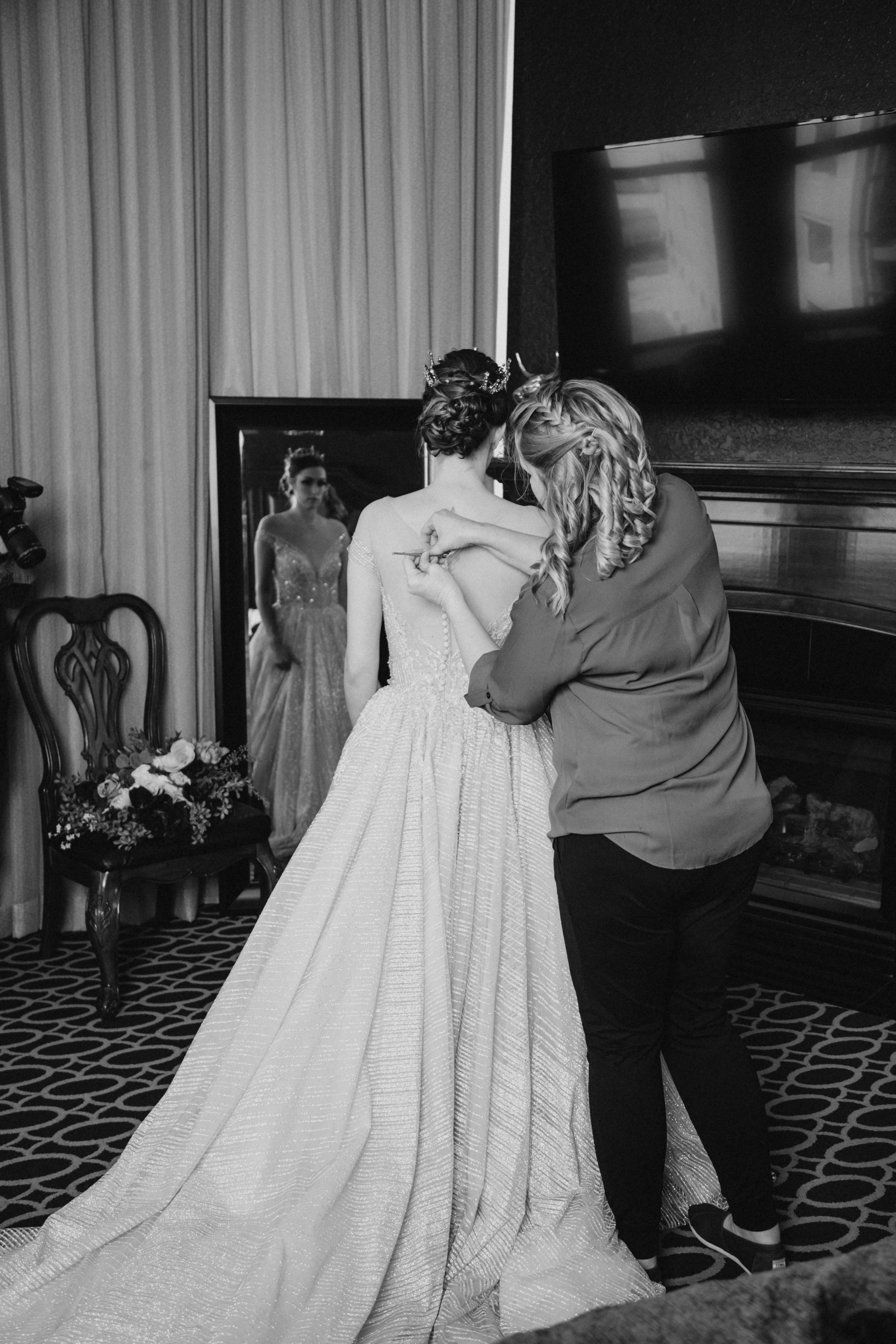 Caitlyn's wedding planner helping her into her dress