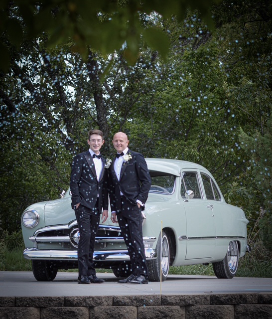 The Jensens posing with a classic vintage car